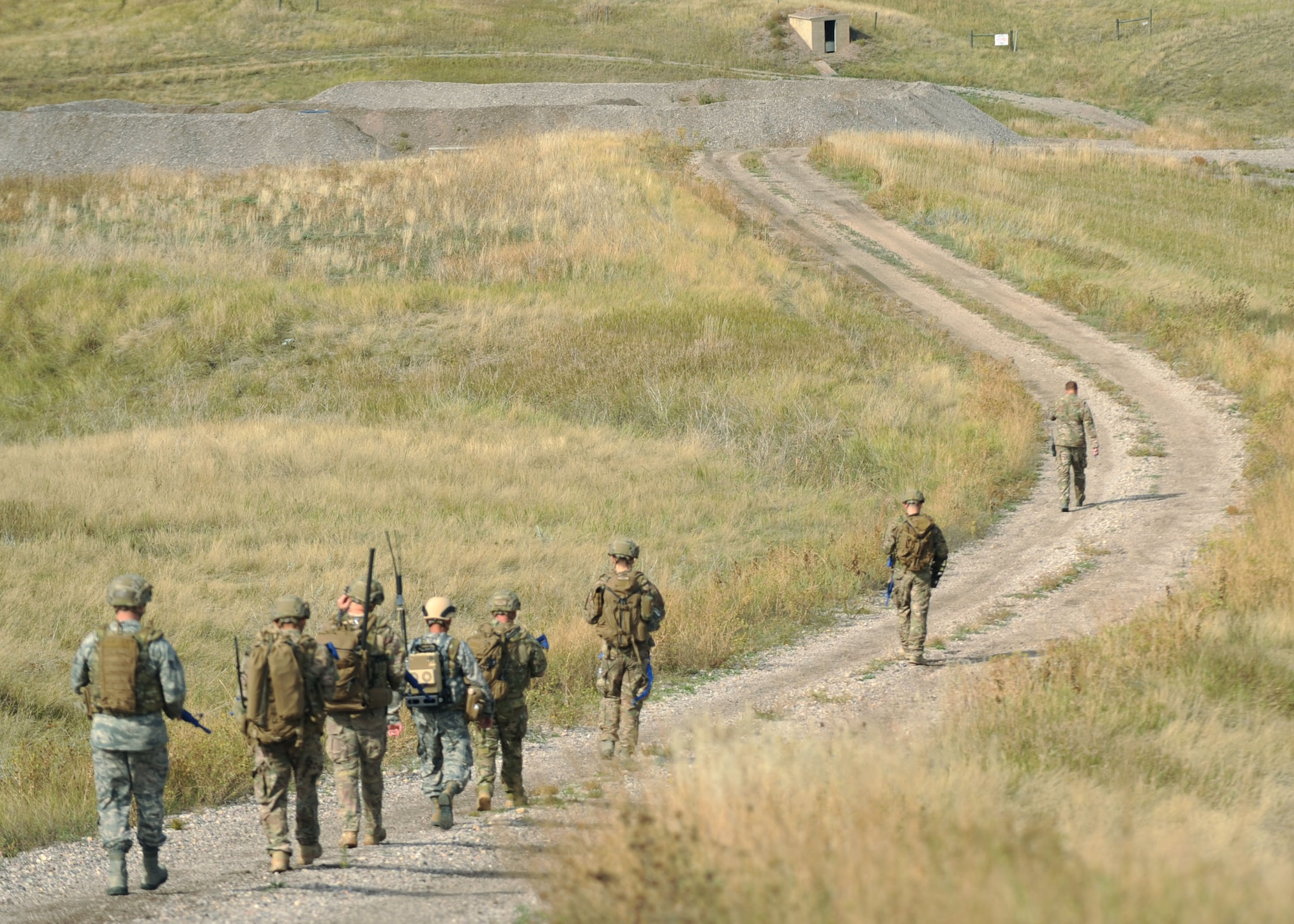 Airmen from the 28th Civil Engineer Squadron explosive ordnance disposal flight advance toward the EOD exercise training site at Ellsworth Air Force Base, S.D., Oct. 6, 2015. During training, Airmen work with several types of explosives, including TNT, thermites and C-4, all of which are used for demolition. (U.S. Air Force photo by Airmen Sadie Colbert/Released)