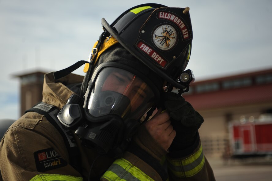 Airman 1st Class Jacquob Fitzgerald, 28th Civil Engineer Squadron firefighter, tightens his helmet strap during a hazardous material training exercise at Ellsworth Air Force Base, S.D., Oct. 9, 2015. The exercise was held to strengthen the fire department’s team cohesion and improve mission readiness. (U.S. Air Force photo by Airman Sadie Colbert/Released)