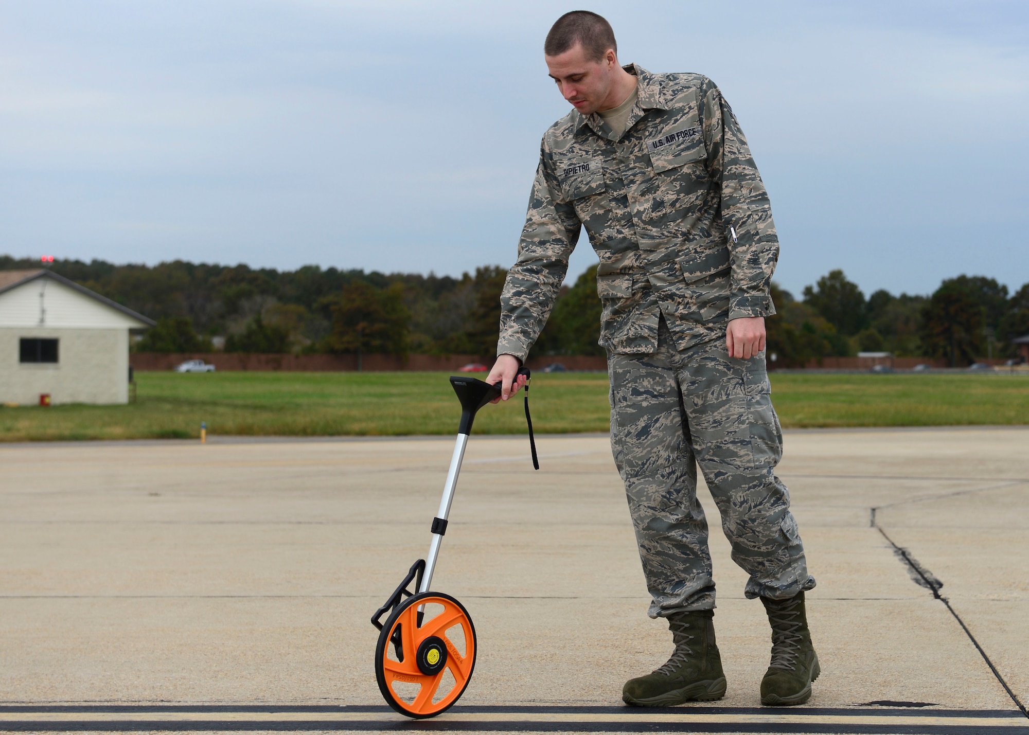 U.S. Air Force Senior Airman Jon Dipietro, 1st Operations Support Squadron Airfield Management shift lead, measures lines for proper width on the flight line at Langley Air Force Base, Va., Oct. 16, 2015. The distance between the painted lines and markers determines the path an aircraft is approved for. (U.S. Air Force photo by Airman 1st Class Derek Seifert/ Released)