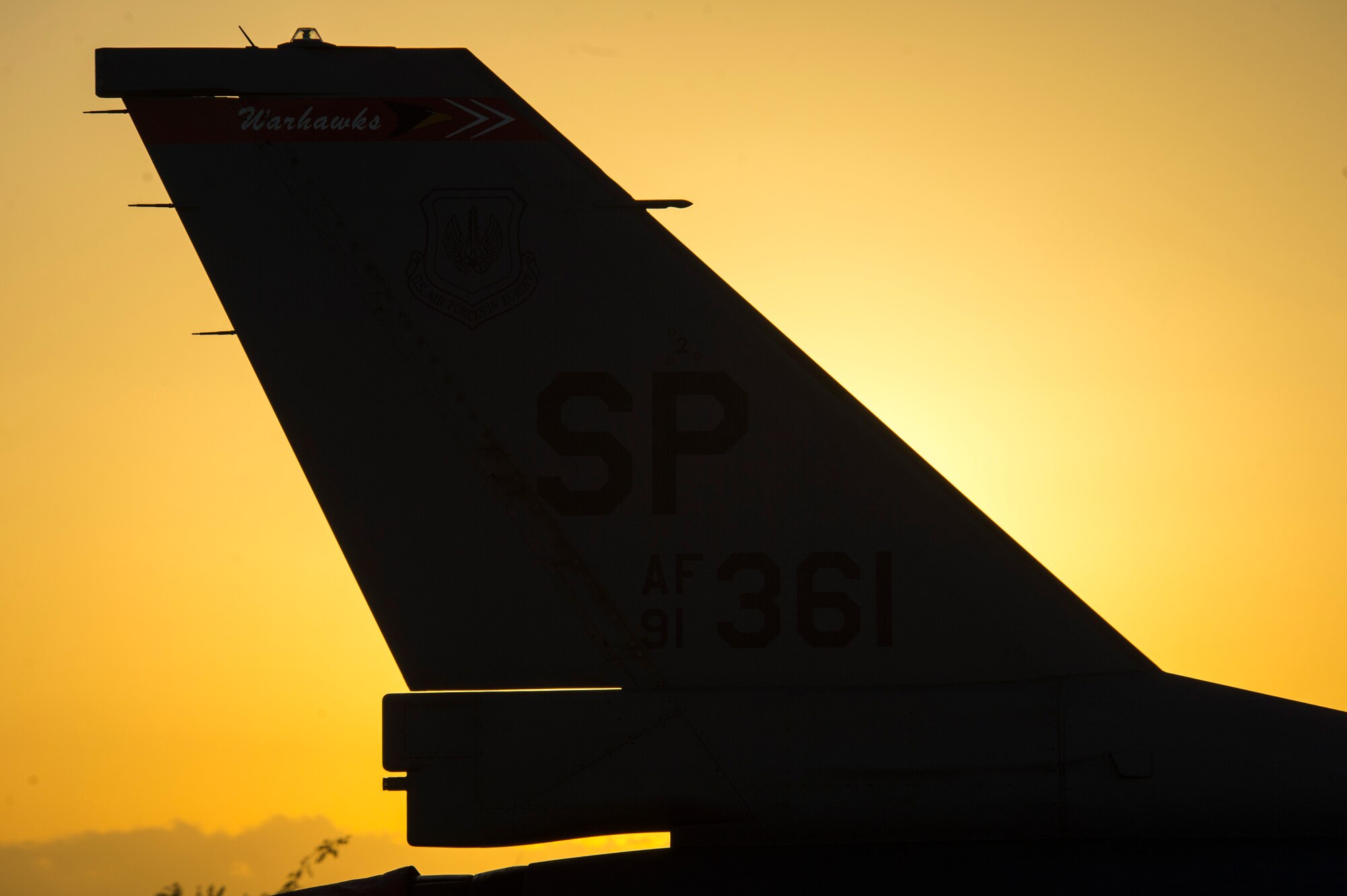 TRAPANI AIR BASE, Italy - The tail of an F-16 Fighting Falcon fighter aircraft assigned to the 480th Fighter Squadron at Spangdahlem Air Base, Germany, sits in front of the sun before the start of the Trapani Air Show at Trapani Air Base, Italy, Oct. 19, 2015. Two F-16s from Spangdahlem participated in the air show, one for a formation flyover and the other for a static display. The Trapani Air Show kicked off Trident Juncture 2015, a training exercise involving more than 30 Allied and Partner Nations taking place throughout Italy, Portugal and Spain. (U.S. Air Force photo by Airman 1st Class Luke Kitterman/Released)