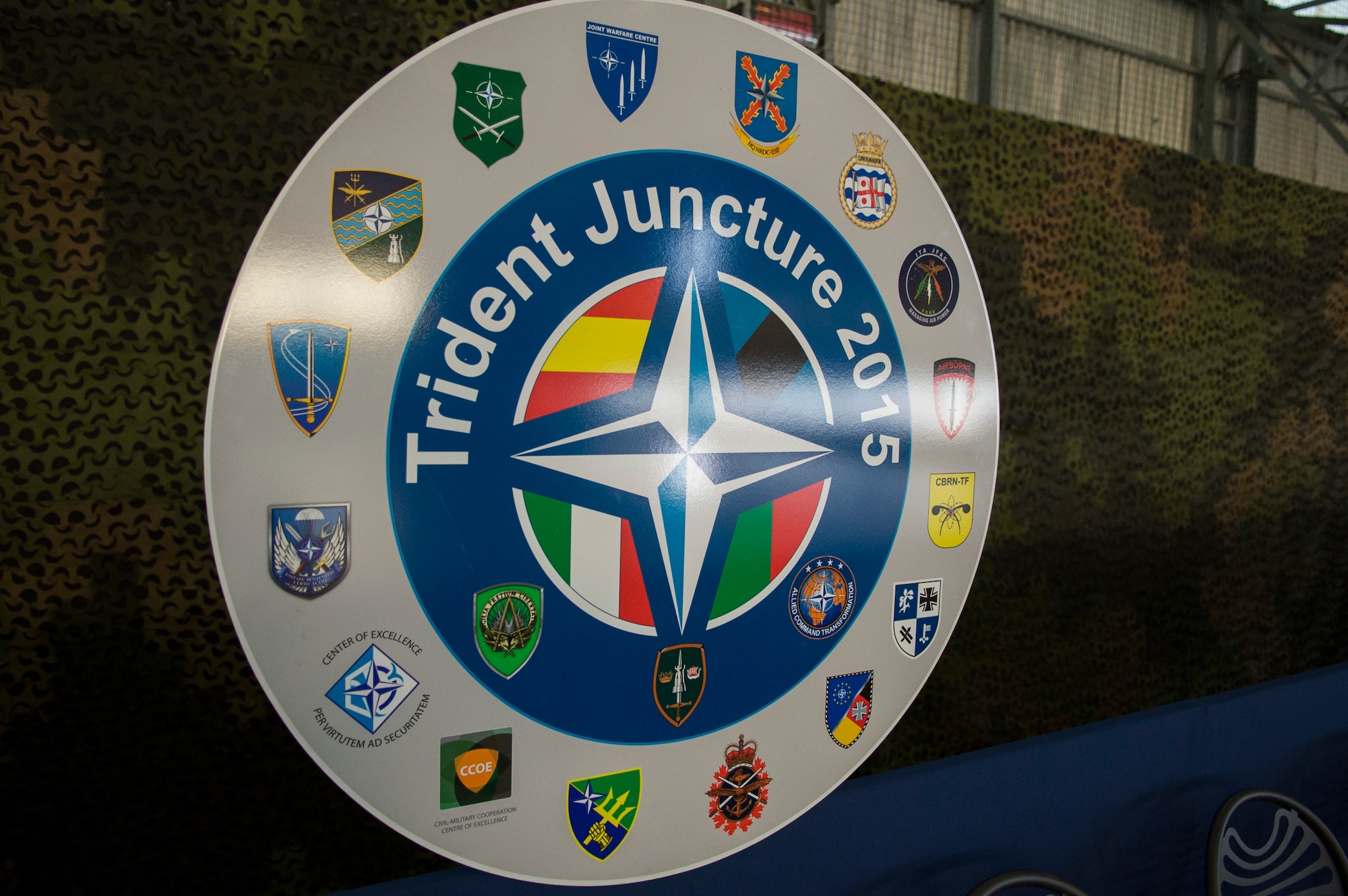 TRAPANI AIR BASE, Italy - The Trident Juncture 2015 emblem is presented at a ceremony before the start of the Trapani Air Show at Trapani Air Base, Italy, Oct. 19, 2015. The ceremony involved key speakers from different nations communicating the importance of this multinational exercise. Trident Juncture 2015 is a multiservice, multinational training exercise involving more than 30 Allied and Partner Nations taking place throughout Europe, mainly in Italy, Portugal and Spain. (U.S. Air Force photo by Airman 1st Class Luke Kitterman/Released)