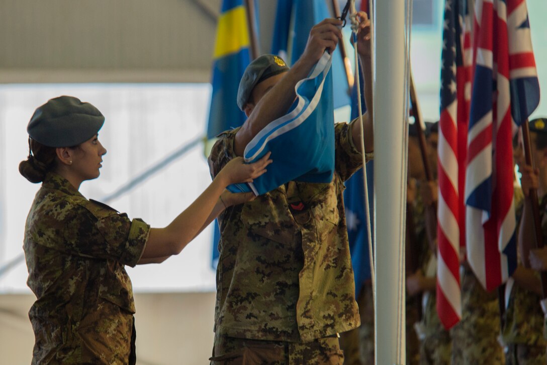 TRAPANI AIR BASE, Italy - Italian Air Force Airmen raise the Trident Juncture 2015 flag during a ceremony before the start of the Trapani Air Show at Trapani Air Base, Italy, Oct. 19, 2015. The Trapani Air Show kicked off Trident Juncture 2015, a training exercise involving more than 30 Allied and Partner Nations taking place throughout Italy, Portugal, Spain, the Atlantic Ocean, the Mediterranean Sea, Canada, Norway, Germany, Belgium and the Netherlands. (U.S. Air Force photo by Airman 1st Class Luke Kitterman/Released)