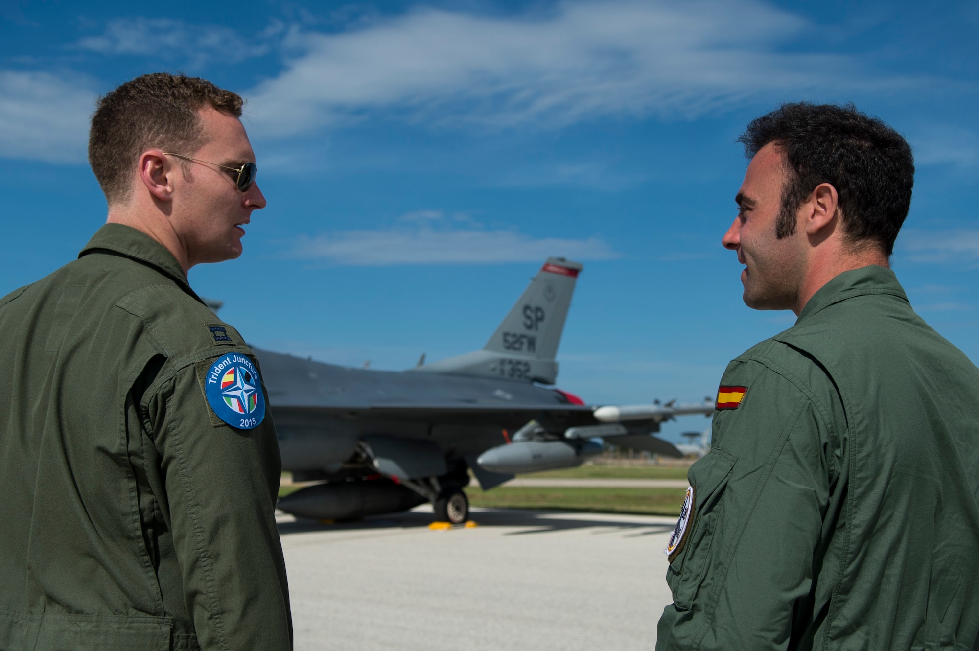 An F-16 Fighting Falcon fighter aircraft pilot, assigned to 480th Fighter Squadron, Spangdahlem Air Base, Germany, talks with a Spanish Air Force pilot during the Trapani Air Show at Trapani Air Base, Italy, Oct. 19, 2015. The Trapani Air Show kicked off Trident Juncture 2015, a training exercise involving more than 30 Allied and Partner Nations taking place throughout Europe mainly in Italy, Portugal and Spain. (U.S. Air Force photo by Airman 1st Class Luke Kitterman/Released)