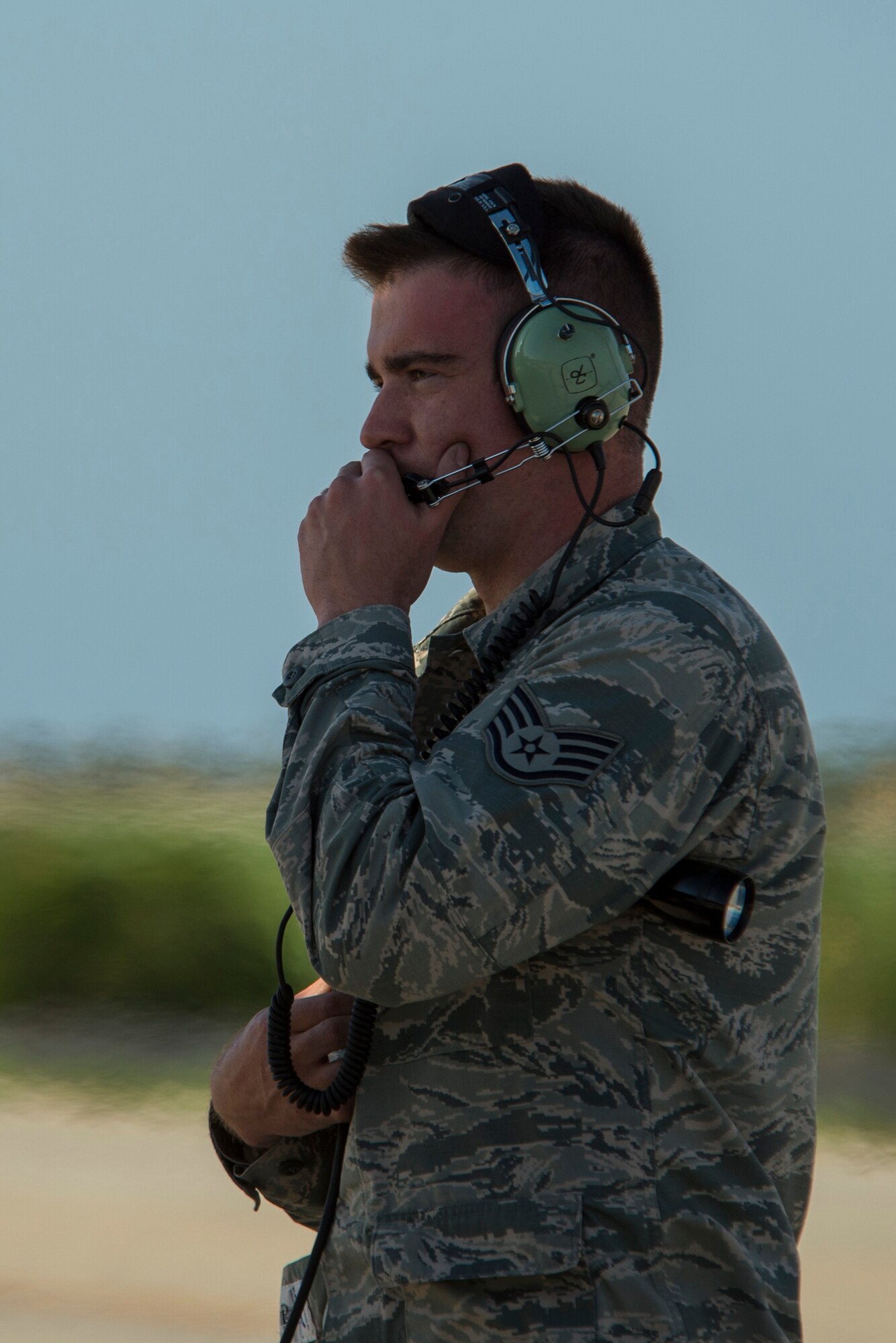 U.S. Air Force Staff Sgt. Daniel Walker, a 52nd Aircraft Maintenance Squadron crew chief, communicates through his headset before the start of the Trapani Air Show at Trapani Air Base, Italy, Oct. 19, 2015. The Trapani Air Show kicked off Trident Juncture 2015, a training exercise involving more than 30 Allied and Partner Nations taking place throughout Italy, Portugal, Spain, the Atlantic Ocean, the Mediterranean Sea, Canada, Norway, Germany, Belgium and the Netherlands. (U.S. Air Force photo by Airman 1st Class Luke Kitterman/Released)