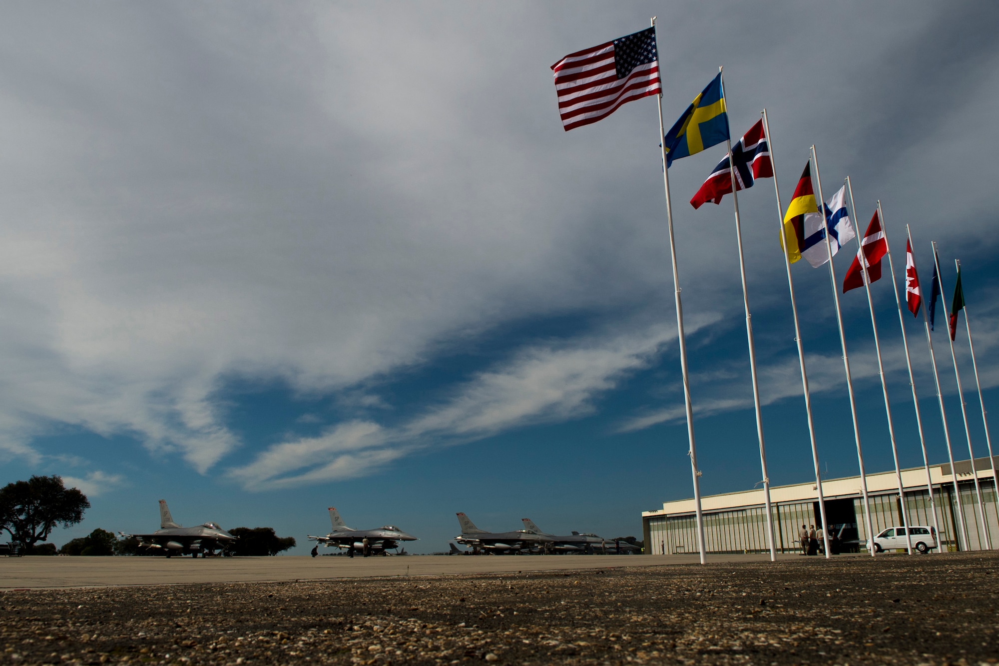BEJA AIR BASE, Portugal - A row of F-16 fighter aircraft from multiple nations are lined up on the flightline at Beja Air Base, Portugal. Several F-16 Fighting Falcons from the 480th Fighter Squadron, Spangdahlem Air Base, Germany, are  here in support of Exercise Trident Juncture 2015, a multiservice, multinational exercise geared at demonstrating NATO's ability to respond to large-scale crises. The F-16s are among 11 U.S. airframes participating in this year's exercise.  (U.S. Air Force photo by Airman 1st Class Luke Kitterman/Released)