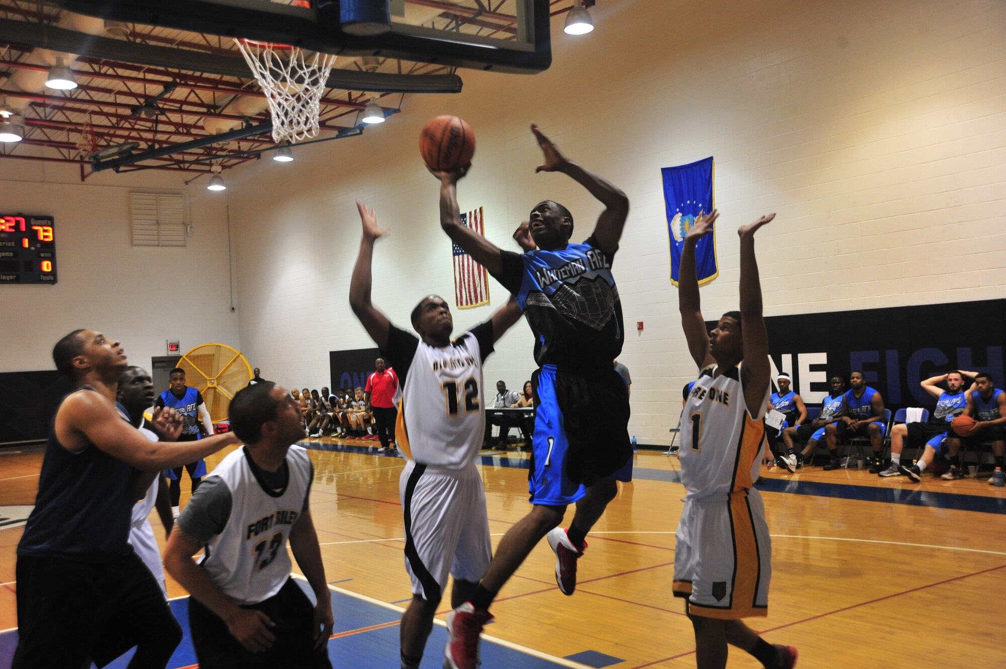 U.S. Air Force Airman 1st Class Gregory Perkins, 509th Security Forces Squadron, drives to the basket against two defenders during the Whiteman Varsity basketball game at Whiteman Air Force Base, Mo., Oct. 10, 2015. Whiteman played a total of four games in a two day span.   U.S. Air Force photo by Airman 1st Class Jovan Banks/released