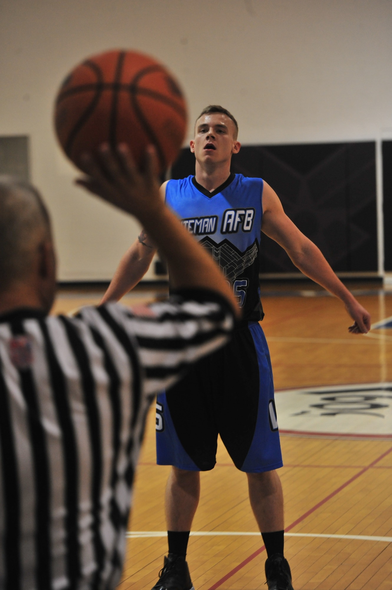 U.S. Air Force Airman 1st Class Austin King, 509th Aircraft Maintenance Squadron, stretches at the free throw line during the Whiteman Varsity basketball game at Whiteman Air Force Base, Mo., Oct. 10, 2015. Whiteman hosted two teams during the four game series. (U.S. Air Force photo by Airman 1st Class Jovan Banks/released)
