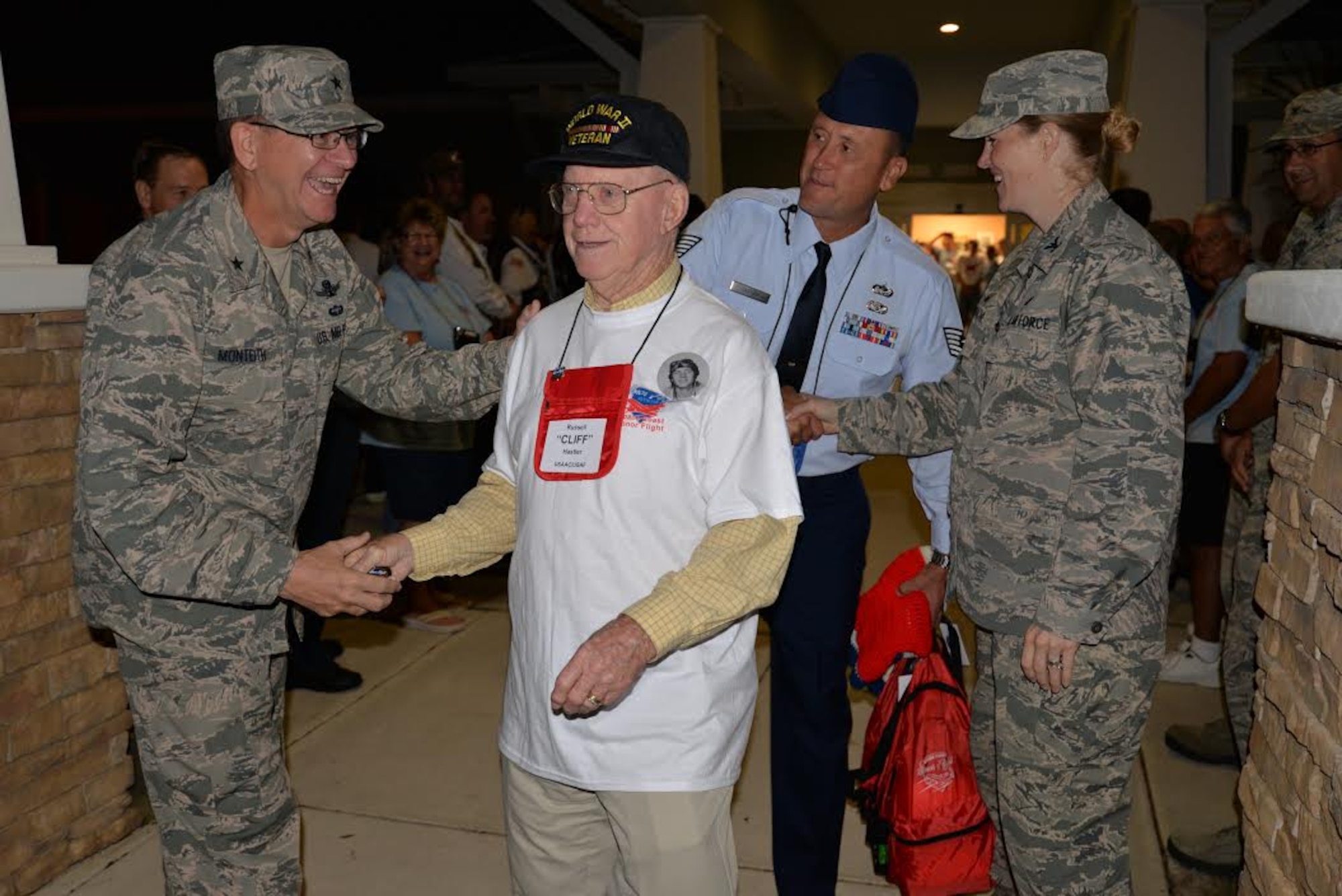 Brig. Gen. Wayne Monteith, 45th Space Wing commander, coins Russell “Cliff” Hastler, a U.S. Army Air Corps and Air Force veteran who served in World War II, the Korean and Vietnam wars, at the Wickham Senior Center in Melbourne, Fla., Oct. 17, 2015. Hastler was escorted by Tech. Sgt. Scott Tantius from the Patrick Air Force Base Honor Guard on a one-day trip to see his war memorials in Washington, D.C. (U.S. Air Force photo by 1st Lt. Alicia Premo/Released)