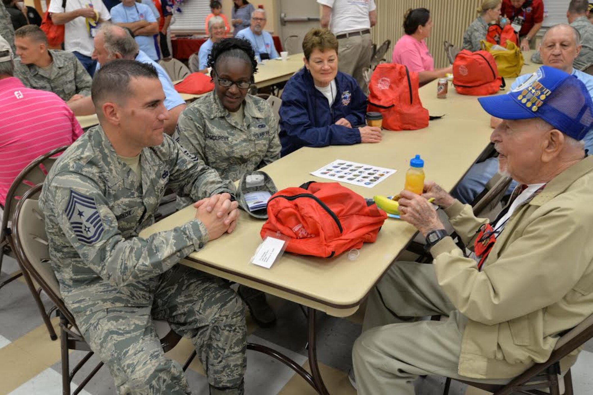 Chief Master Sgt. Jason Lamoureux, 45th Space Wing command chief, left, and his wife Senior Master Sgt. Kashanda Lamoureux, Air Force Technical Applications Center Inspector General superintendent, to his left, listen as Eric Relinger, a veteran of the U.S. Army, tells them stories from when he served Oct. 17, 2015, at the Wickham Senior Center in Melbourne, Fla. Space Coast Honor Flight is an organization that provides World War II, Korean and Vietnam War Veterans an opportunity to visit their war memorials on a one-day trip to Washington, D.C. (U.S. Air Force photo by 1st Lt. Alicia Premo/Released) 