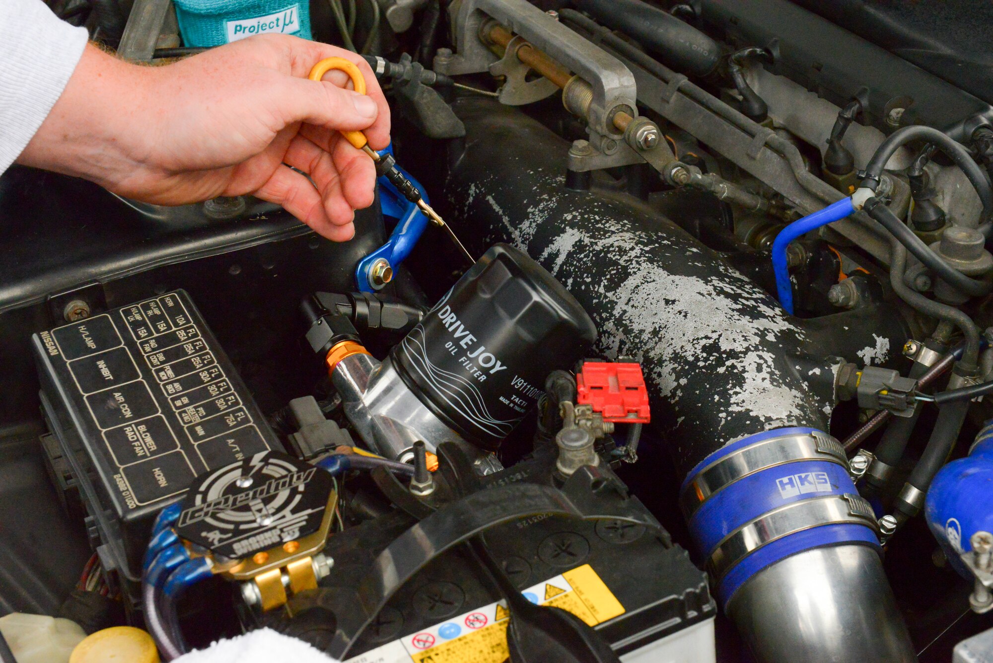 Senior Airman Thomas Kirts, 374th Civil Engineer Squadron driver operator, checks the oil levels of his car in preparation for a race at Fuji Speedway, Japan, Oct. 17, 2015. Kirts continually upgrades his vehicles with new parts and conducts his own maintenance to compete in races. (U.S. Air Force photo by Airman 1st Class Elizabeth Baker/Released)