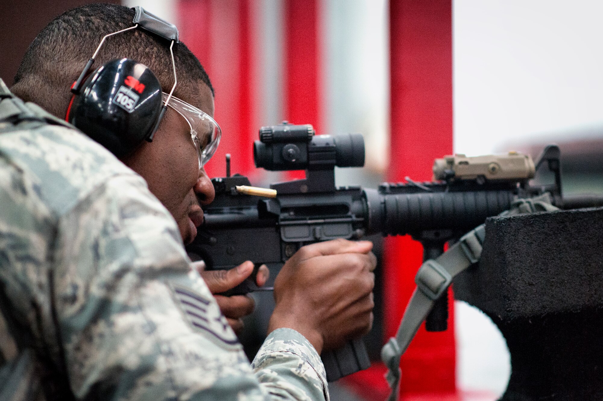 Staff Sgt. Louis Bradshaw, 374th Security Forces Squadron criminal investigator, fires an M-4 Carbine during a qualification test at Yokota Air Base, Japan, Oct. 8, 2015. In order to qualify for deployment in combat arms, each Airman must have at least a score of 44 out of 63 rounds to pass. (U.S. Air Force photo by Airman 1st Class Delano Scott/Released)