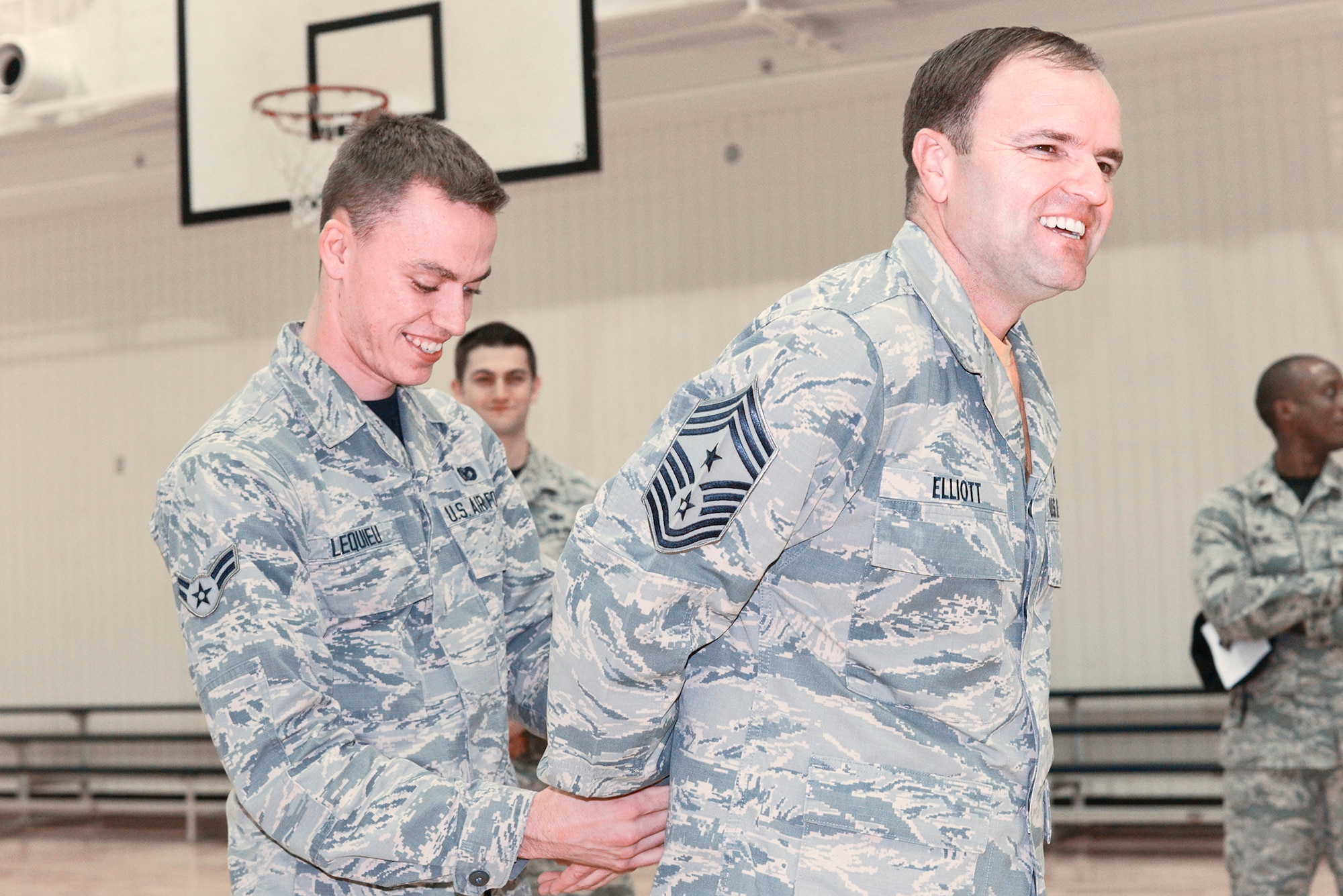 Airman 1st Class Quentin Lequieu, 374th Security Forces Squadron patrolman, handcuffs Chief Master Sgt. Paul Elliott, 374th Airlift Wing command chief, during a driving under the influence rodeo at Yokota Air Base, Japan, Oct. 16, 2015. Rodeo participants were escorted to a station manned by members of the 374th Airlift Wing Judge Advocate General's Corps for a mock trial, after failing a field sobriety test. (U.S. Air Force photo by Senior Airman David C. Danford/Released)