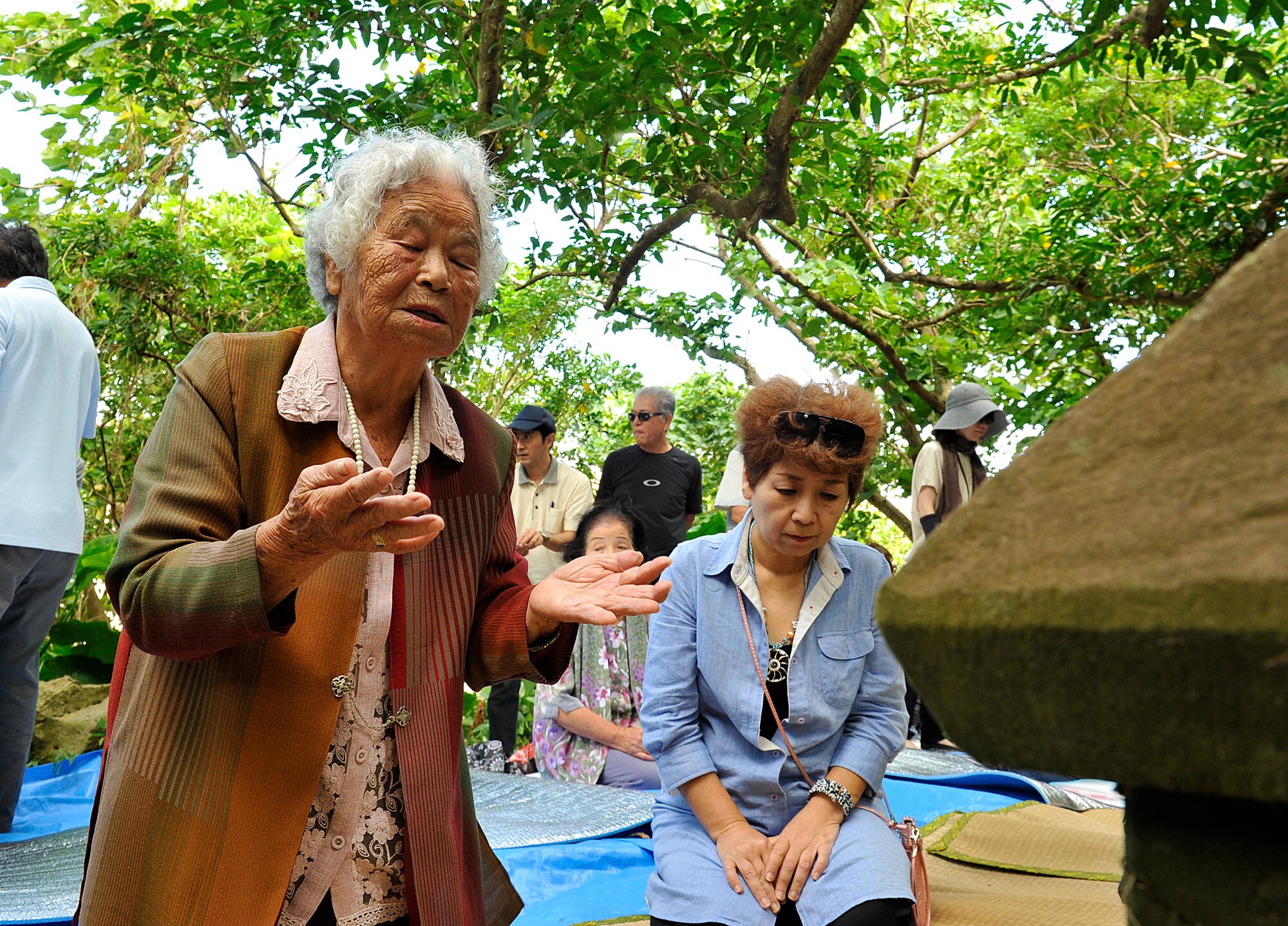 Shizuko Yara, a local Okinawan, prays for good health, safety and happiness in front of a tomb during the annual sacred sites visit at the Morine Bijiru Oct. 21, 2015, on Kadena Air Base, Japan. A total of 40 local Okinawans from Okinawa City visited multiple sites to clean up, pray, have a ceremonial meal and enjoy social hours. (U.S. Air Force photo by Naoto Anazawa)