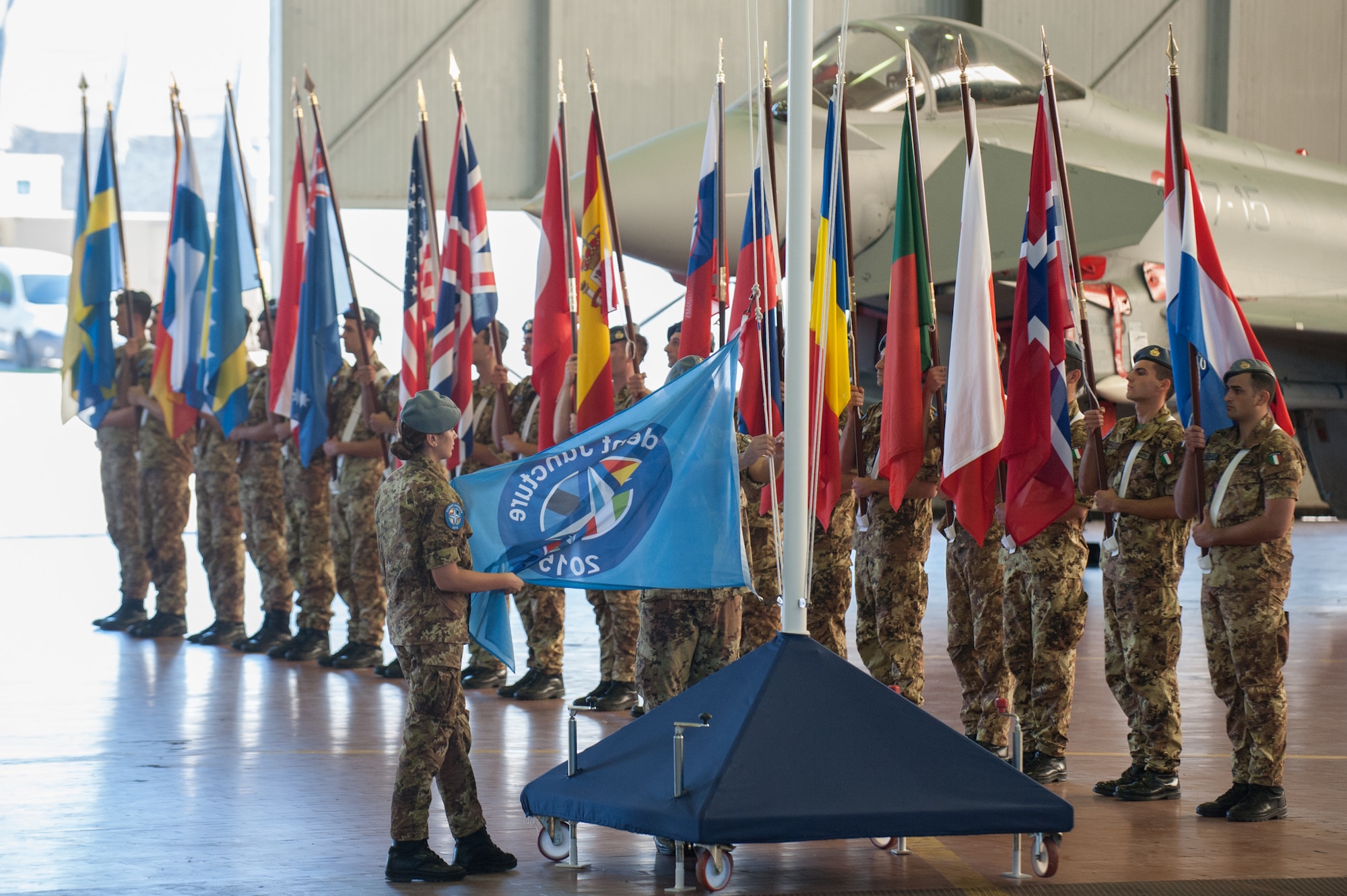 Opening Ceremony of Exercise Trident Juncture at Trapani Air Base, Italy. Rising of the Trident Juncture 2015 flag. More than 5,000 U.S. service members will participate in NATO’s Trident Juncture 2015 exercise conducted in Spain, Portugal and Italy, Belgium, Canada, Germany, The Netherlands, Norway and at sea, in the Atlantic Ocean and Mediterranean Sea. Trident Juncture is the largest NATO LIVEX to be conducted in the past 20 years, and serves as an annual NATO Response Force (NRF) certification exercise for 2016.  The U.S. Army, Air Force, Navy and Marine Corps and Special Operations personnel supporting the exercise will arrive from European and CONUS locations, to include some Army and Air National Guard assets. Special Operations Command Europe (SOCEUR), will be certified during this exercise and assume the role as the Special Operations Component Command for the NRF in 2016. Exercise Trident Juncture runs until Nov. 6, 2015.