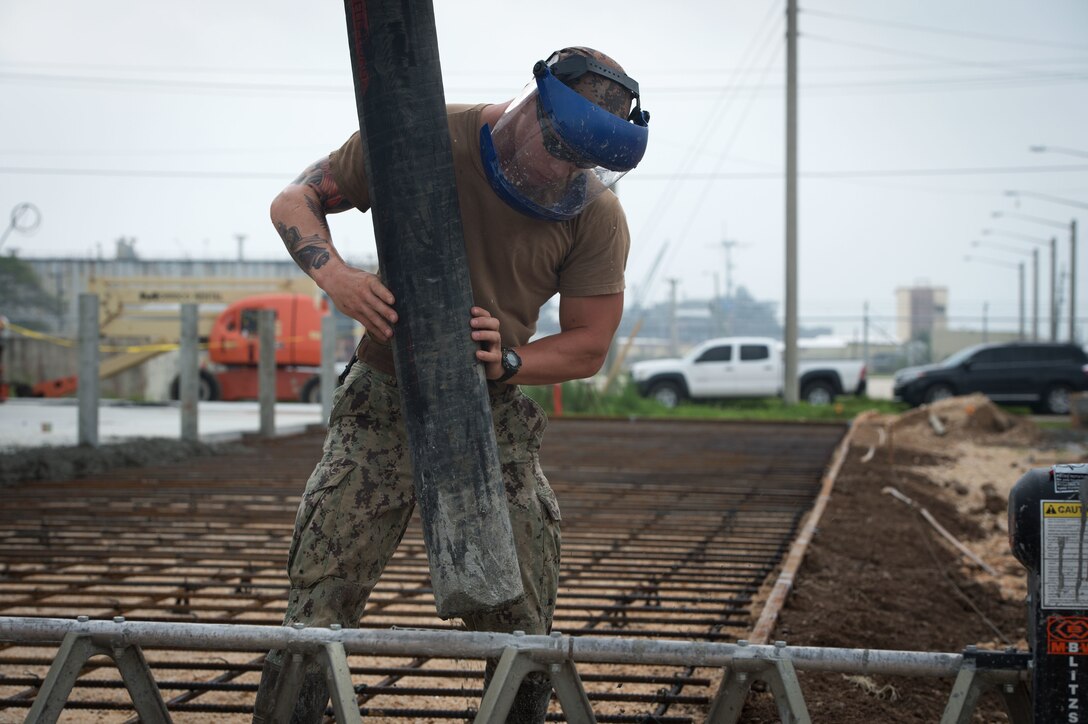 U.S. Navy Petty Officer 3rd Class Joshua Donahue places concrete during a project on Naval Base Guam, Guam, Oct. 20, 2015. Donahue is a builder assigned to Naval Mobile Construction Battalion 1. NMCB 1 is assigned to Commander, Task Force 75, the primary expeditionary task force responsible for the planning and execution of coastal riverine operations, explosive ordnance disposal, diving engineering, construction and underwater construction in the U.S. 7th fleet area of responsibility. U.S. Navy photo by Petty Officer 1st Class Ace Rheaume