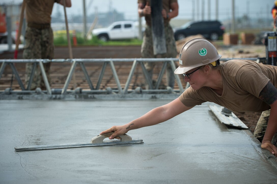 U.S. Navy Petty Officer 3rd Class Mallory Getty uses a magnesium float to smooth concrete during a construction placement project on Naval Base Guam, Guam, Oct. 20, 2015. Getty is a builder assigned to Naval Mobile Construction Battalion 1. U.S. Navy photo by Petty Officer 1st Class Ace Rheaume