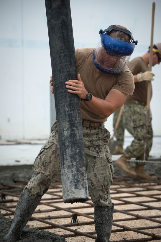 U.S. Navy Petty Officer 3rd Class Joshua Donahue places concrete during a construction placement project on Naval Base Guam, Guam, Oct. 20, 2015. Donahue is a builder assigned to Naval Mobile Construction Battalion 1. U.S. Navy photo by Petty Officer 1st Class Ace Rheaume