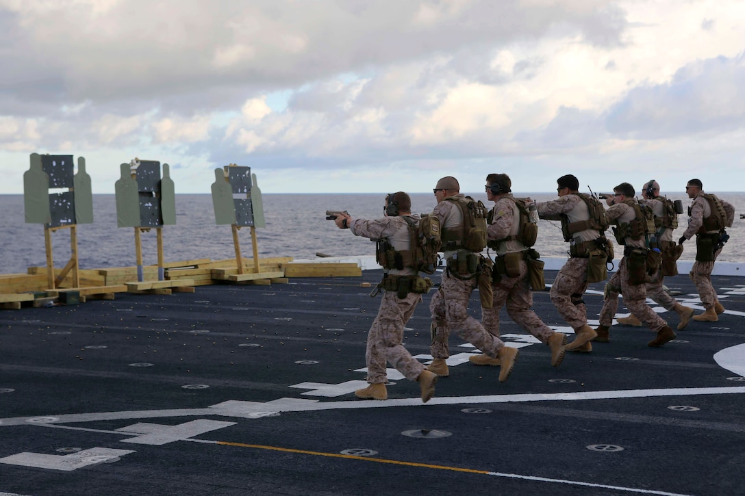 U.S. Marines fire while walking toward stationary targets during a deck shoot aboard the USS Arlington in the Atlantic Ocean, Oct. 12, 2015. U.S. Marine Corps photo by Cpl. Jeraco Jenkins