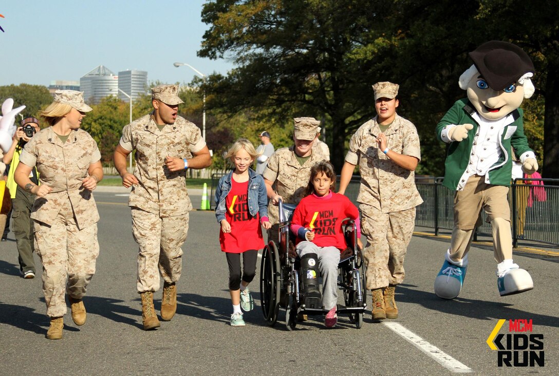 Sgt. Deanna Cohen, Sgt. Christopher Bustamante, Cpl. Elizabeth Maywalt and Cpl. Skye Davis, all of whom are stationed at Marine Barracks Washington, D.C., motivate two participants in the Marine Corps Marathon Kids Run Saturday. Nearly 3,600 children ages 5-12 paraticipated in the one-mile run held in the Pentagon’s parking lot.

