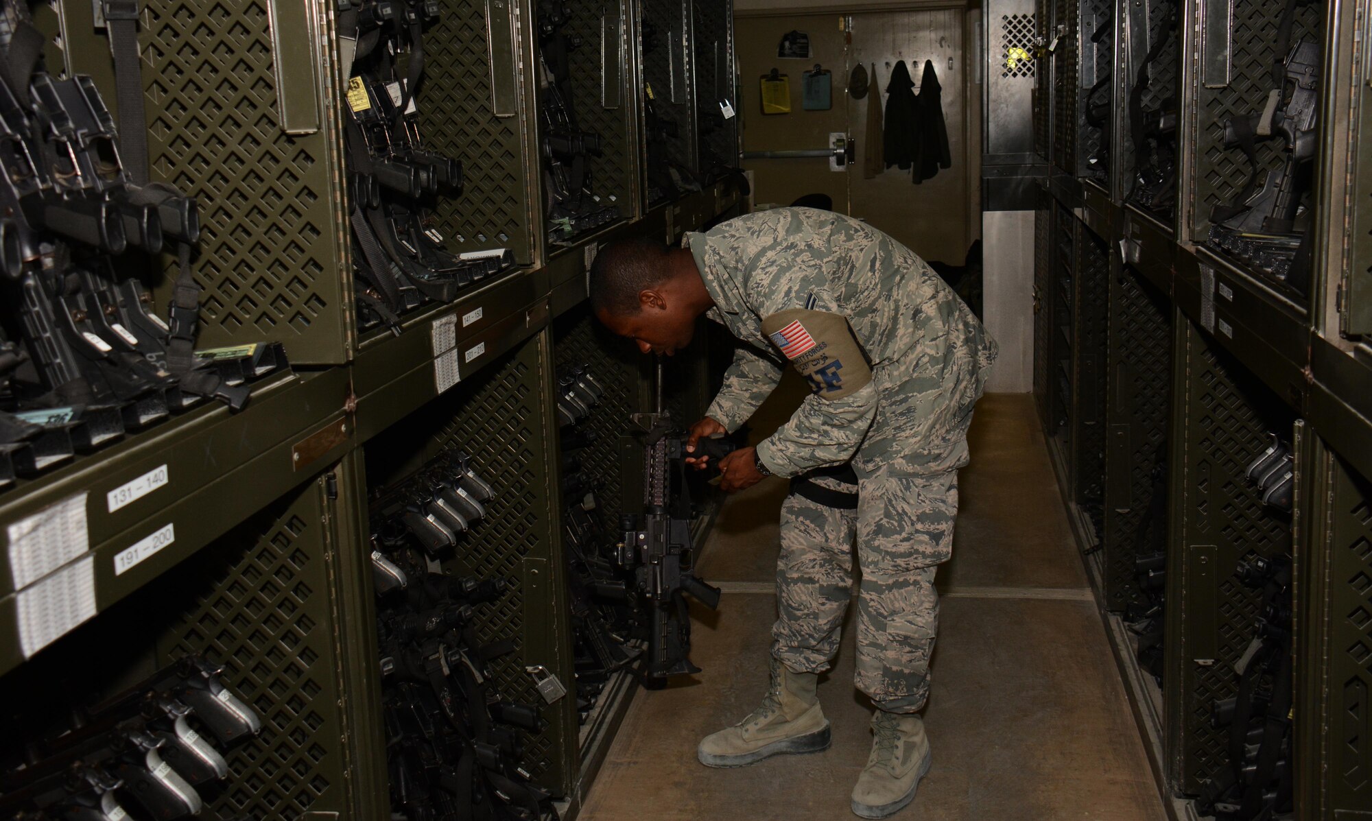 Airman 1st Class, Cerrome Pridgen, 379th Security Forces Squadron, pulls an M-4 rifle from a weapons rack inside the 379th SFS Armory at Al Udeid Air Base, Qatar Oct. 21. The armory maintains more than $5 million in weapons and equipment including radios, batons, pistols and rifles . (U.S. Air Force photo/Tech. Sgt. James Hodgman)
