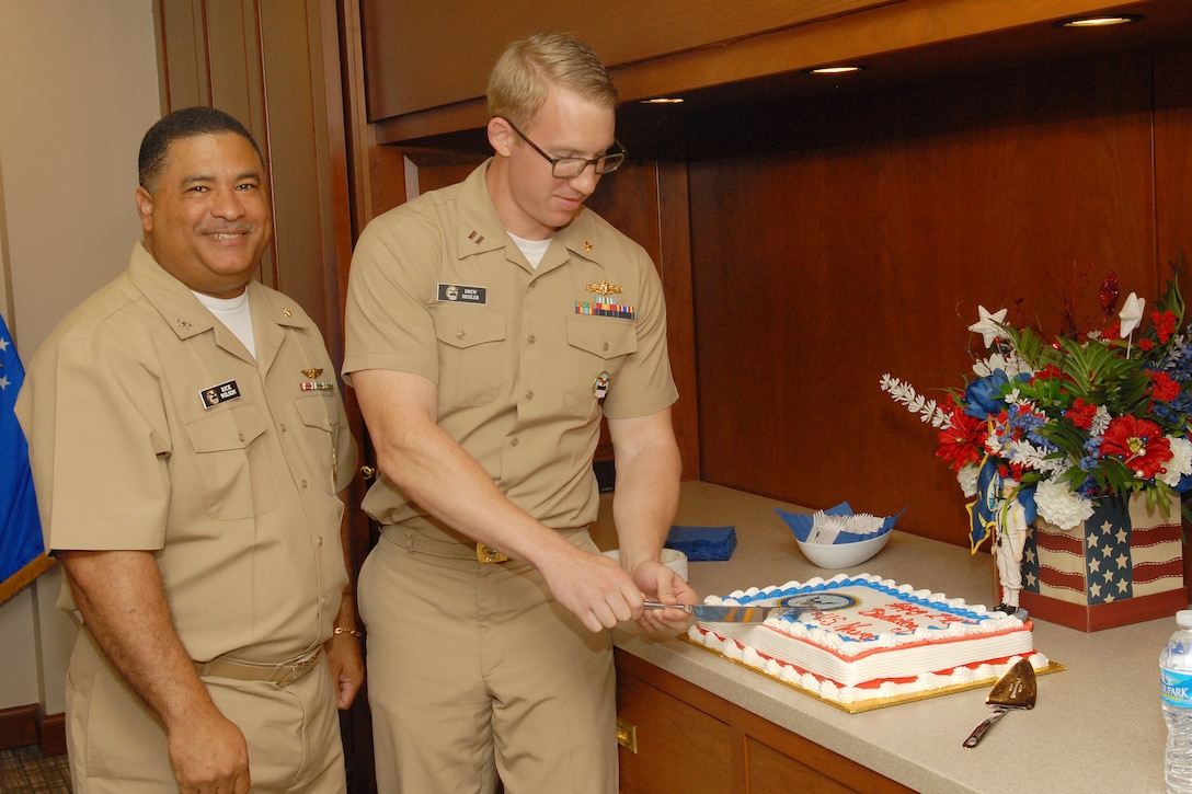 Navy Capt. Ricardo Wilson, DLA Troop Support director of Process Procurement Support (left), and Navy Lt. Andrew Heisler (right), of the Subsistence supply chain, cut a ceremonial birthday cake during a celebration Oct. 13 in Philadelphia honoring the service’s 240th birthday. 