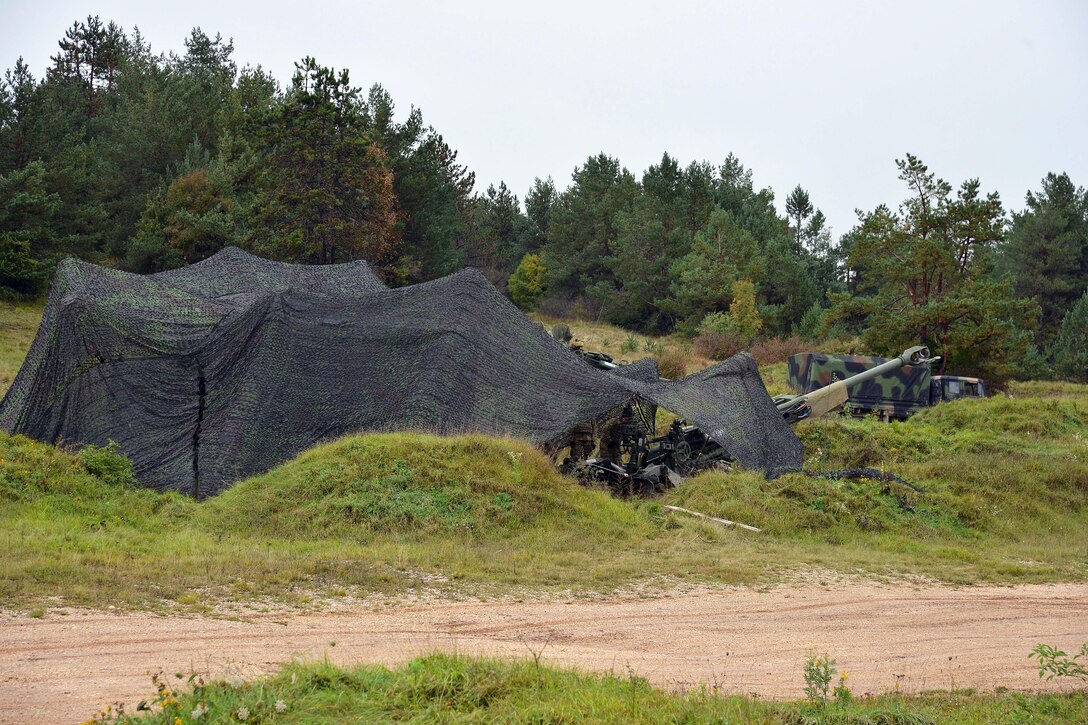U.S. soldiers conceal an M119 howitzer during Exercise Rock Proof V at Pocek Range in Postonja, Slovenia, Oct. 15, 2015. U.S. Army photo by Paolo Bovo