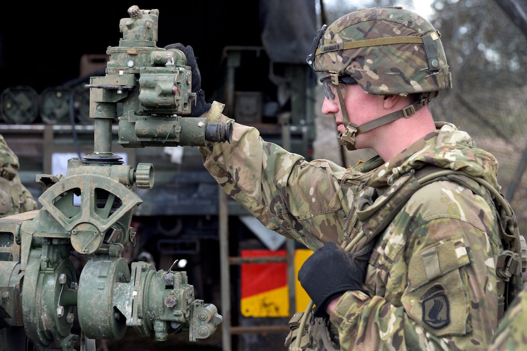 A U.S. soldier checks a compass during preparation for firing an M119 howitzer during Exercise Rock Proof V at Pocek Range in Postonja, Slovenia, Oct. 15, 2015. U.S. Army photo by Paolo Bovo