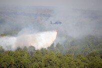 A Texas Army National Guard UH-60 Black Hawk from the Austin Army Aviation Facility assists in suppressing a wildfire in Bastrop County, Texas. The Texas National Guard mobilized aviation assets from Austin, Grand Prairie and San Antonio to help combat the fire that burned about 4,200 acres and destroyed nearly one dozen homes.