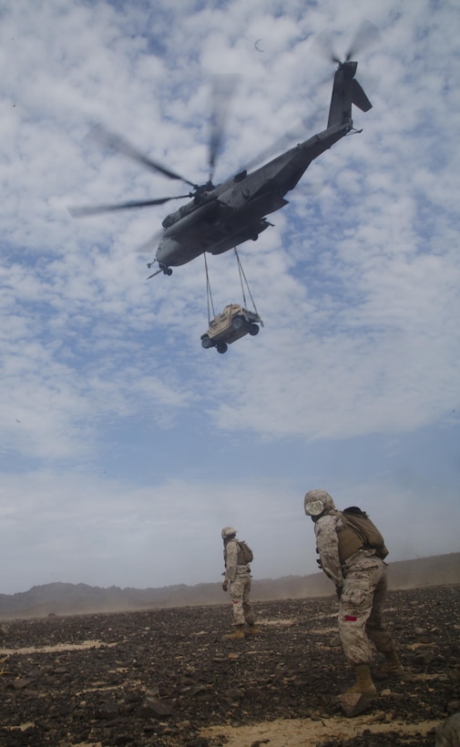 Marines watch a CH-53E Super Stallion helicopter carry away a Humvee after a successful sling-load operation during an assault support tactics exercise at Landing Zone Bull, Chocolate Mountain Aerial Gunnery Range, Calif., Oct. 12, 2015. U.S. Marine Corps photo by Cpl. Summer Dowding