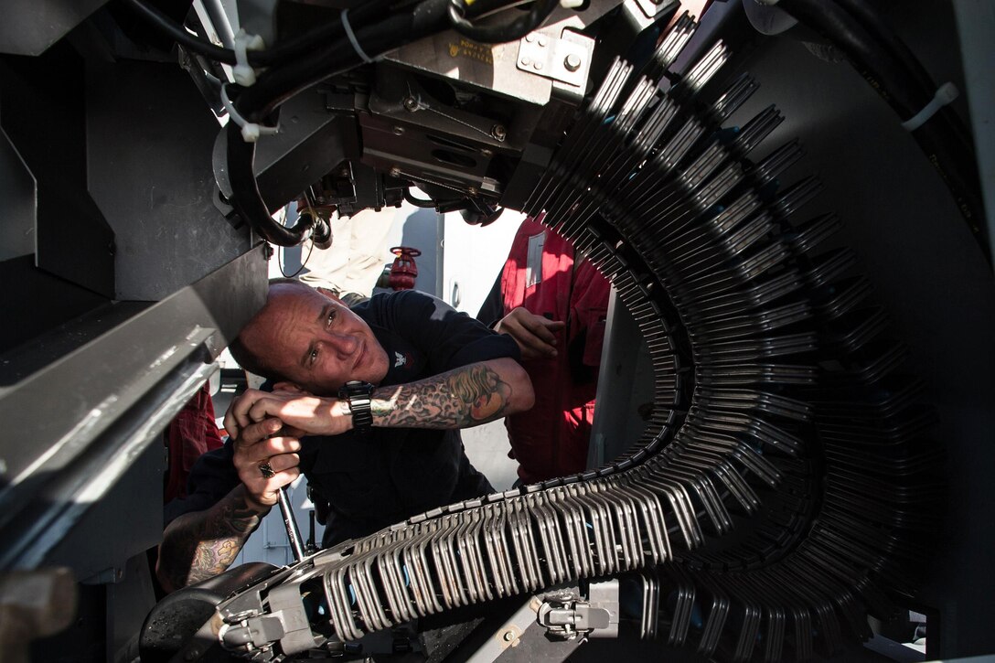 U.S. Navy Petty Officer 1st Class John Barkmeyer releases an ammo-feed chute from an MK 38 25mm machine gun following a live-fire exercise aboard the aircraft carrier USS Ronald Reagan at sea south of Japan, Oct. 20, 2015. The Ronald Reagan and its embarked air wing, Carrier Air Wing 5, protects and defends the collective maritime interests of the United States, allies and partners in the Indo-Asia-Pacific region. U.S. Navy photo by Petty Officer 3rd Class Nathan Burke