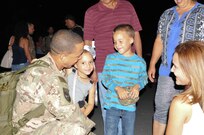 Sgt. Hector A. Solivan reunites with his daughter, Nayelis, and son, Hector, as his wife, Elismar Ruiz, and his parents, Hector Solivan and Edith Diaz, watch in excitement during the 35th Signal Battalion homecoming on Oct. 15, 2015.