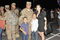Staff Sgt. Walter Santiago poses with his wife, Gloriannie, and sons, Rodrigo and Diego, after reuniting with them at the 35th Signal Battalion homecoming on Oct. 15.
