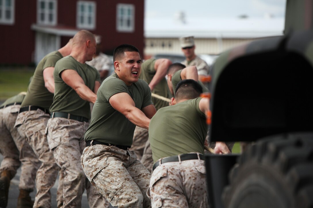 Marines with Headquarters and Headquarters Squadron pull a seven-ton tactical vehicle during the bi-annual field meet against Marine Wing Headquarters Squadron 2 at Marine Corps Air Station Cherry Point, N.C., May 22, 2015. Marines with H&HS and MWHS-2 went head-to-head in a tug-of-war, a 7-ton pull, relay races and other events to build teamwork and camaraderie.