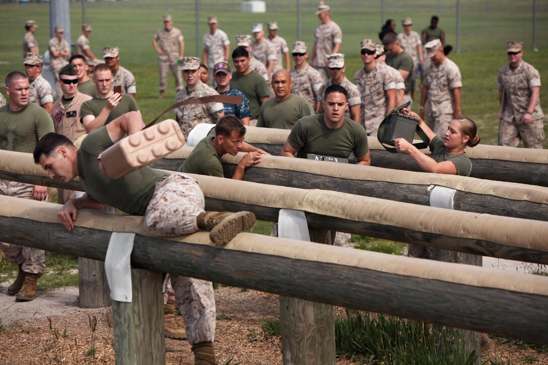 Marines with Headquarters and Headquarters Squadron maneuver an obstacle as a team during the bi-annual field meet against Marine Wing Headquarters Squadron 2 at Marine Corps Air Station Cherry Point, N.C., May 22, 2015. Marines with H&HS and MWHS-2 went head-to-head in a tug-of-war, a 7-ton pull, relay races and other events to build teamwork and camaraderie.