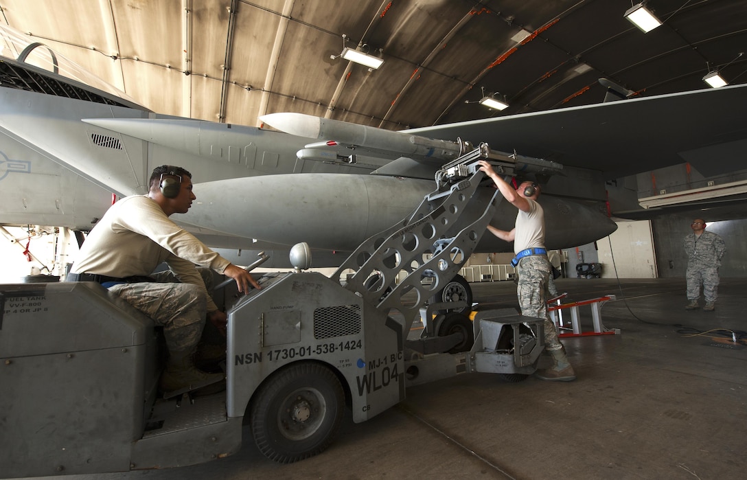 U.S. Air Force Staff Sgt. Mike Goncalves, right, secures a LAU-128 missile with Senior Airman Jacob Montiel during a weapons loading competition on Kadena Air Base, Japan, Oct. 19, 2015. Goncalves is a weapons load crew chief and Montiel is a weapons load crew member -- both are assigned to the 44th Fighter Squadron. The weapons load competition is a tradition held to raise morale, give airmen motivation to outperform their peers and set a higher standard for crews to come. U.S. Air Force photo by Airman Zackary A. Henry
