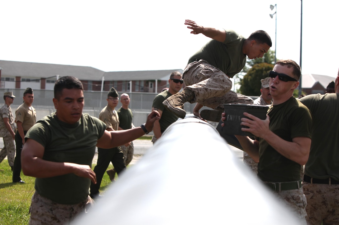 Marines with Marine Wing Headquarters Squadron 2 maneuver an obstacle as a team during the bi-annual field meet against Headquarters and Headquarters Squadron at Marine Corps Air Station Cherry Point, N.C., May 22, 2015. Marines with H&HS and MWHS-2 went head-to-head in a tug-of-war, a 7-ton pull, relay races and other events to build teamwork and camaraderie.
