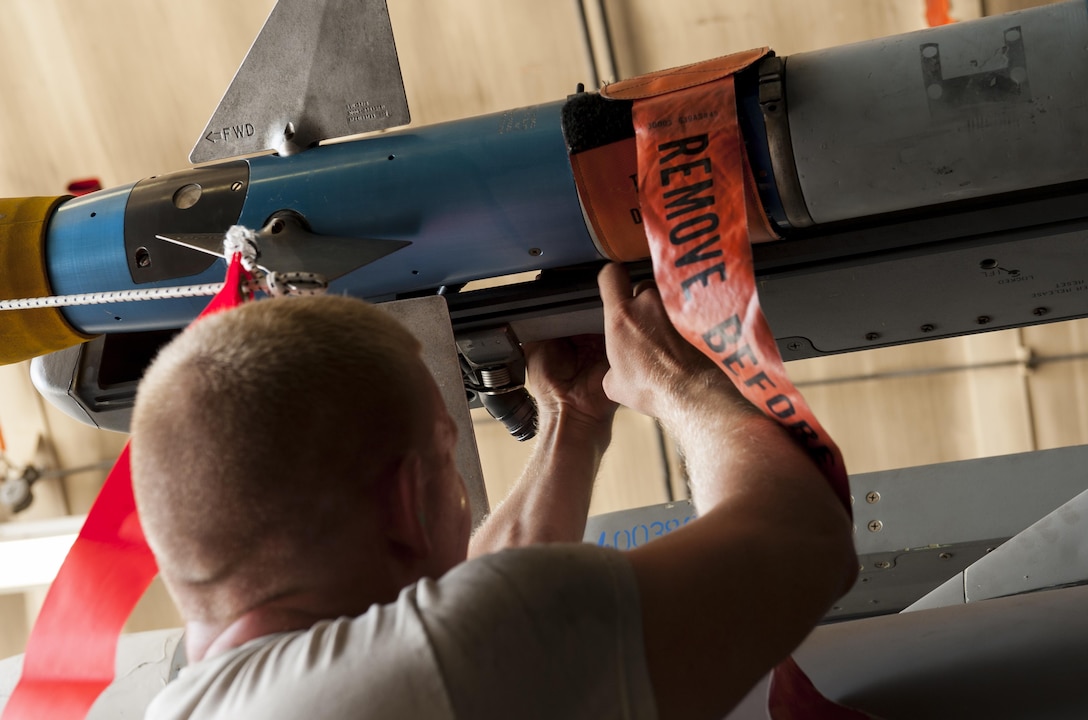 U.S. Air Force Staff Sgt. Mike Goncalves secures an AIM-9L/M Sidewinder missile during a weapons loading competition on Kadena Air Base, Japan, Oct. 19, 2015. Goncalves is a weapons load crew chief assigned to the 44th Fighter Squadron. U.S. Air Force photo by Airman Zackary A. Henry