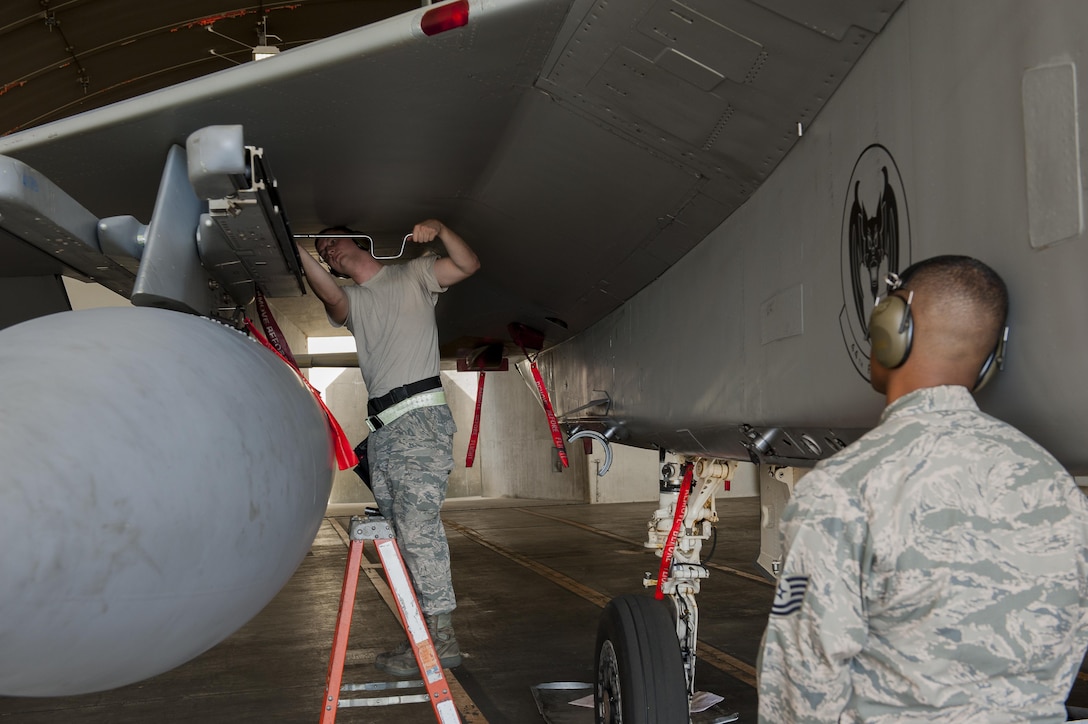 U.S. Air Force Senior Airman John Viktor Non, left, works on the LAU-128 launcher while Tech. Sgt. Marquette Price supervises to ensure the process is done correctly and safely during a weapons loading competition on Kadena Air Base, Japan, Oct. 19, 2015. Viktor Non is a weapons load crew member assigned to the 67th Fighter Squadron and Price is a weapons standardization crew member assigned to the 18th Maintenance Group. U.S. Air Force photo by Airman Zackary A. Henry