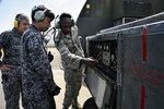 MISAWA AIR BASE, Japan - U.S. Air Force Senior Airman Revel Bellamy, 35th Aircraft Maintenance Squadron avionics journeyman, explains the control panel settings of a portable air conditioning unit to Japan Air Self-Defense Force Staff Sgt. Yuuichi Sato and Tech. Sgt. Yuya Kanamori at Misawa Air Base, Japan, Oct. 1, 2015. As part of a bilateral exchange program, 11 JASDF maintainers from the 8th Air Wing were paired with 35th Maintenance Group Airmen from diverse job specialties. 