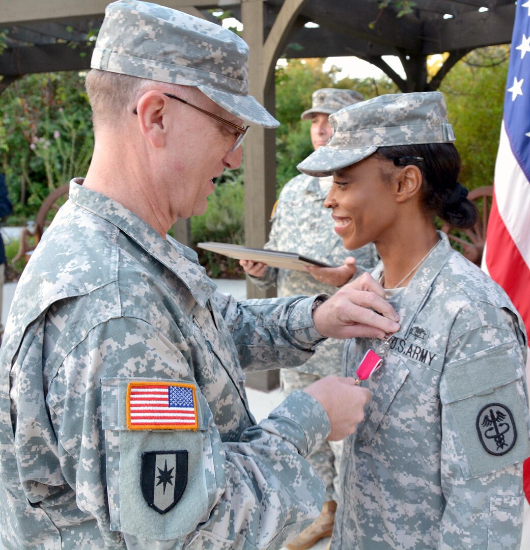 Col. Evan Renz, Brooke Army Medical Center commander, pins the Legion of Merit medal on Command Sgt. Maj. Tabitha Gavia Oct. 6 for exceptionally meritorious service while serving as the command sergeant major at Brooke Army Medical Center.