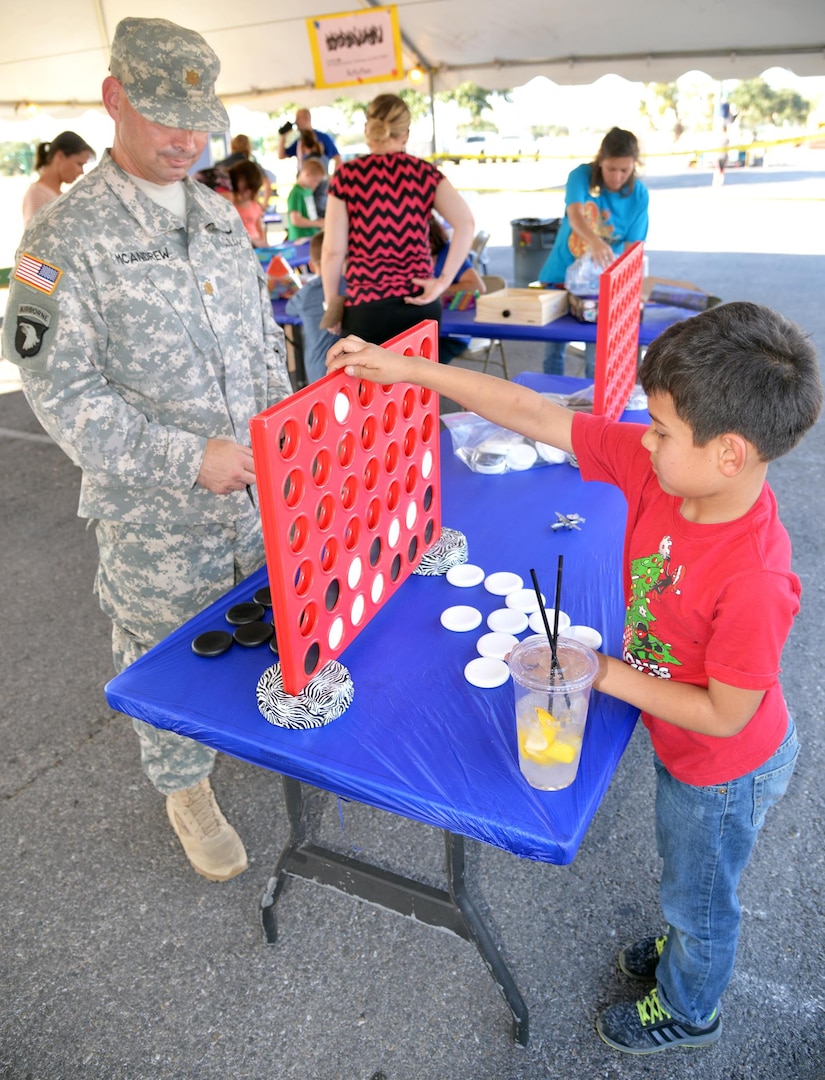 Maj. Kane McAndrew (left), from the Brooke Army Medical Center physical theray department, and his son, Sigi, challenge each other in a game of plinko during the annual Joint Base San Antonio-Fort Sam Houston Oktoberfest celebration Friday.