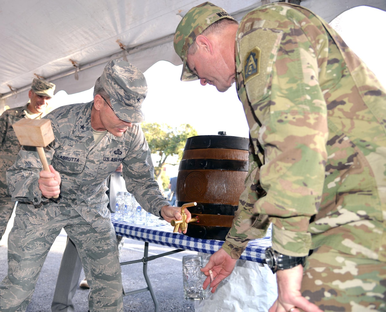 Air Force Brig. Gen. Bob LaBrutta (right) gets ready for the ceremonial tapping of the keg while Army Lt. Gen. Perry Wiggins (left) awaits the first stein of beer Friday at the start of the annual Joint Base San Antonio-Fort Sam Houston Oktoberfest celebration, which ran Friday and Saturday. LaBrutta is commander of the 502nd Air Base Wing and Joint Base San Antonio and Wiggins is commanding general of U.S. Army North (Fifth Army) and senior Army commander of Fort Sam Houston and Camp Bullis.