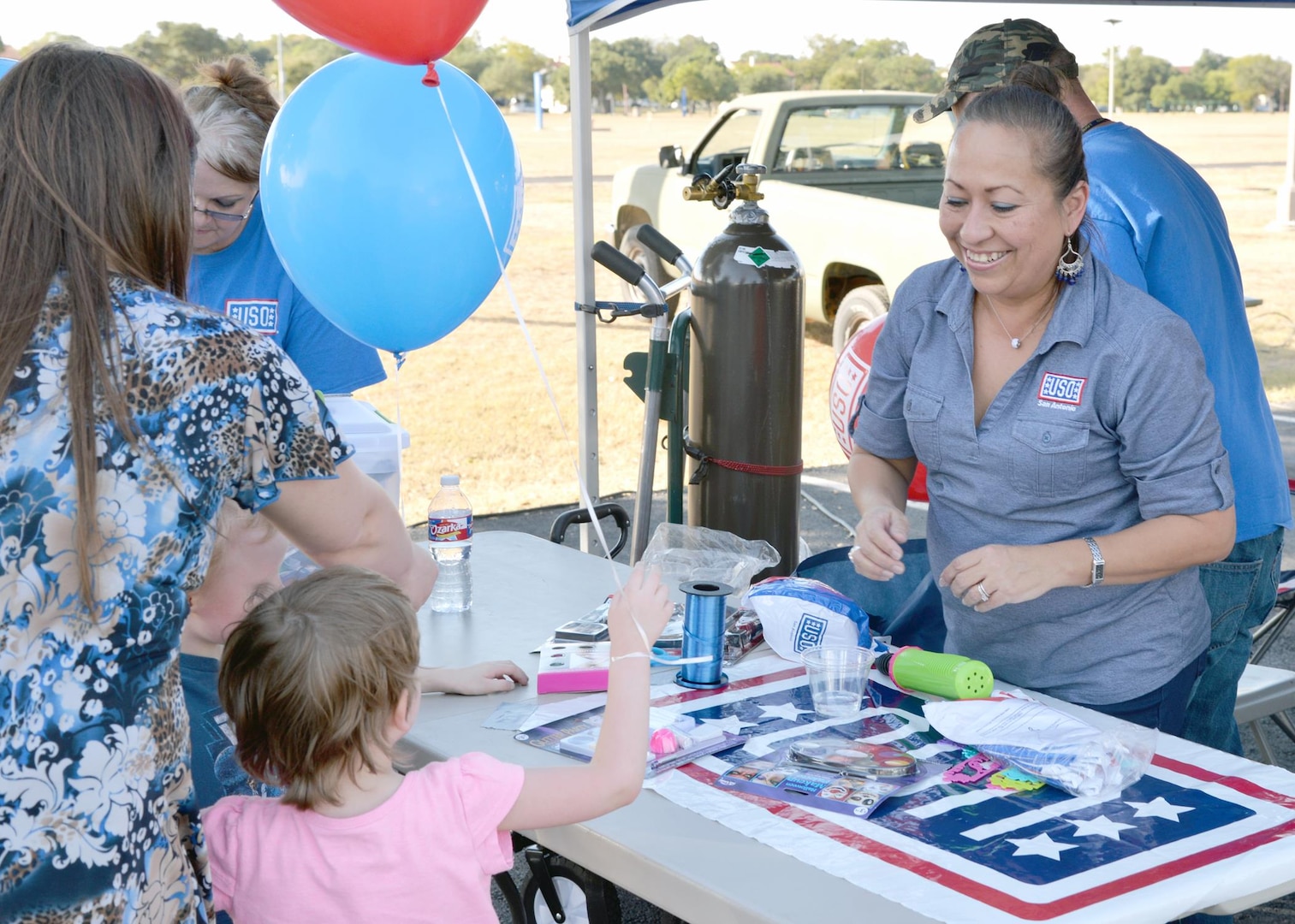 Annette Harris (left) from the San Antonio USO helps give out balloons and other free goodies during the annual Joint Base San Antonio-Fort Sam Houston Oktoberfest celebration Friday.