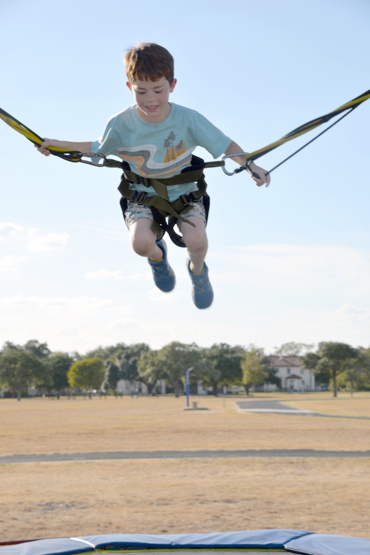 Cameron Zwoll, 8 years old, catches some air on the trampoline bungee attraction at the annual Joint Base San Antonio-Fort Sam Houston Oktoberfest celebration Friday.