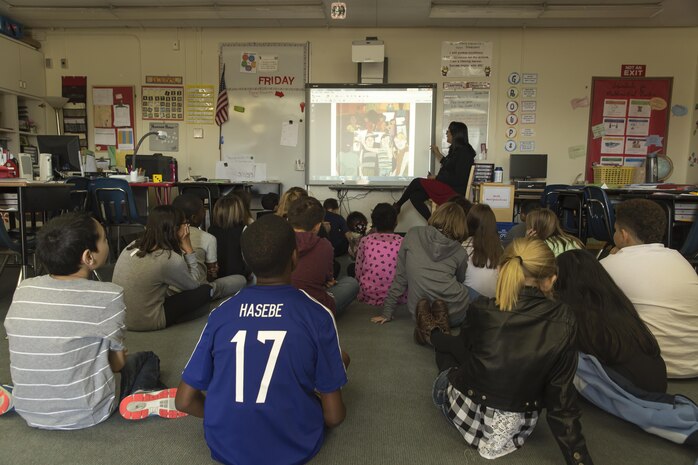 Eileen Meyer, a 5th grade teacher with Matthew C. Perry Elementary, reads to her students as part of an official attempt to break a Guinness World Record aimed to raise awareness about literacy at Marine Corps Air Station Iwakuni, Japan, Oct. 19, 2015. Points of Light, the Barbara Bush Houston Literacy Foundation, Deloitte and hundreds of other organizations hope to read to the most children ever in a 24 hour period by working across time zones and continents. Read Across the Globe is an event during this literacy-awareness week that brings the power of volunteers together to impact literacy in local communities. The current record for most children to in a 24 hour period is 238, 620 with Read Across the Globe aiming to set the new record at 300,000.