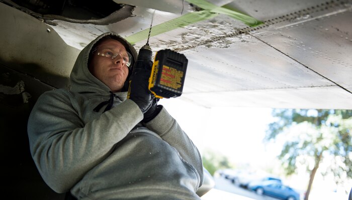 Airman 1st Class Shawn Casey, 437th Maintenance Squadron sheet metal technician, drills into an F-4 Phantom II to make repairs Oct. 18, 2015, on the parade grounds at the Citadel in Charleston, S.C. During the recent storms that impacted the east coast, trees damaged the static aircraft. Parts of the wing, underwing and fuselage were severely compromised. The 437th AMXS volunteered weekends to assist the Citadel in repairing the aircraft. (U.S. Air Force photo/Airman 1st Class Clayton Cupit)