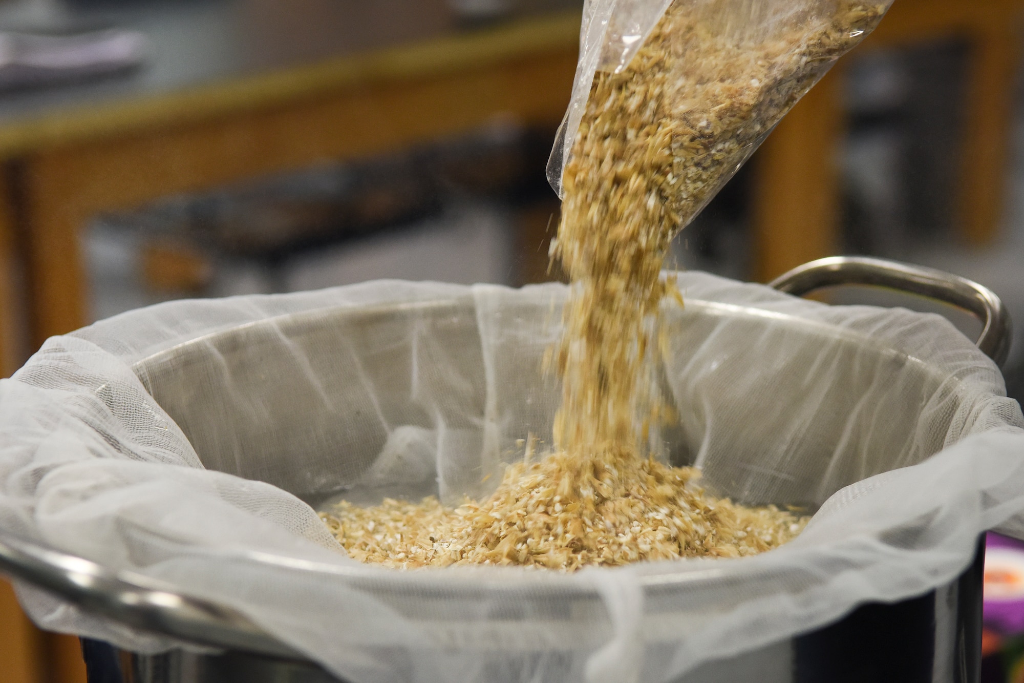 Grain pours into a pot of hot water during a brewing workshop, Oct. 17, 2015, at Wayne Community College in Goldsboro, North Carolina. This portion of the workshop, led by two members of the Seymour Johnson Home Brew Club, taught patrons about the all-grain method of brewing beer. (U.S. Air Force photo/Senior Airman Aaron J. Jenne)