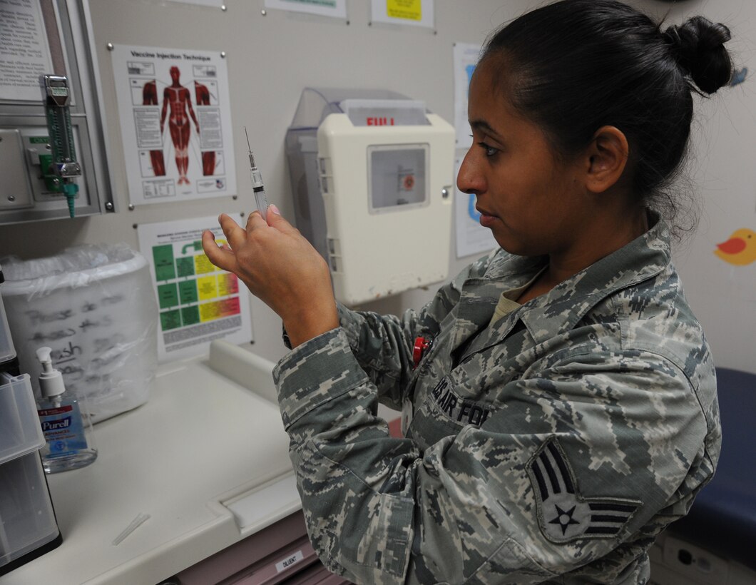 Senior Airman Jesenia Calderon, 22nd Medical Operations Squadron allergy immunization technician, prepares an influenza vaccination, Oct. 21, 2015, at McConnell Air Force Base, Kan. Flu vaccines are mandatory for McConnell service members and civilian employees to prevent illness and stop the spread of the virus. (U.S. Air Force photo by Airman Jenna K. Caldwell)