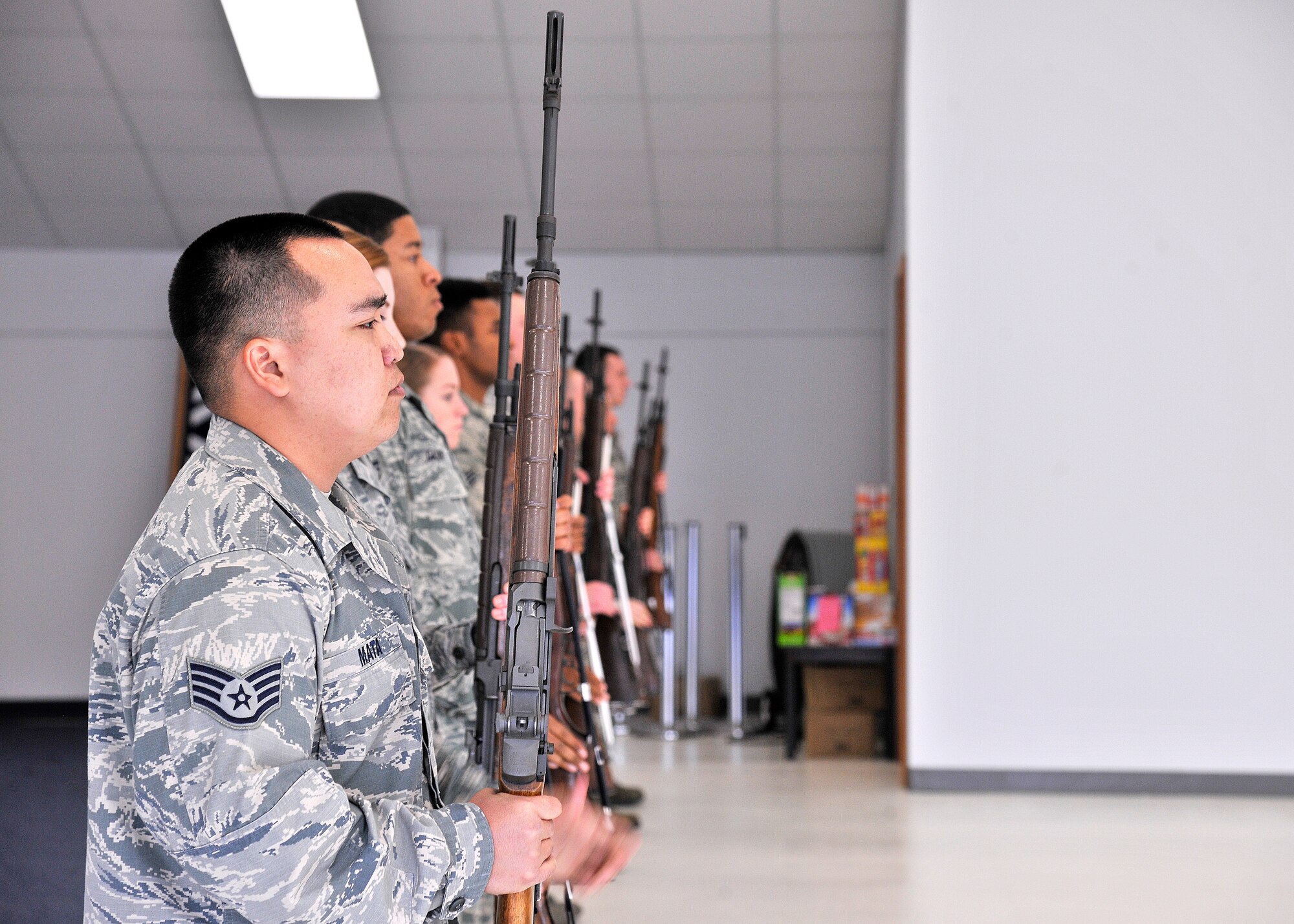 Staff Sgt. Anthony Nguyen Sahagon Mata, ceremonial guardsman, executes presents arms during a firing squad salute demonstration Oct. 21, 2015, on Grand Forks Air Force Base, North Dakota. The Yigo, Guam native was named the Warrior of the Week for the fourth week of October 2015. (U.S. Air Force photo by Senior Airman Xavier Navarro/Released)