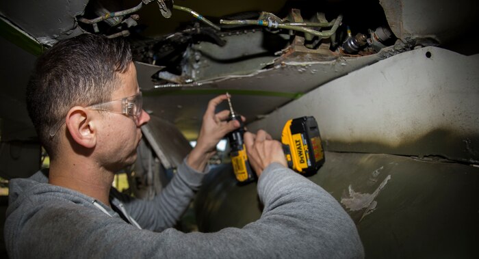 Senior Airman Sean Locklear, 437th Maintenance Squadron sheet metal technician, drills into an F-4 Phantom II to make repairs Oct. 18, 2015, on the parade grounds at the Citadel in Charleston, S.C. During the recent storms that impacted the east coast, trees damaged the static aircraft. Parts of the wing, underwing and fuselage were severely compromised. The 437th AMXS volunteered weekends to assist the Citadel in repairing the aircraft. (U.S. Air Force photo/Airman 1st Class Clayton Cupit)
